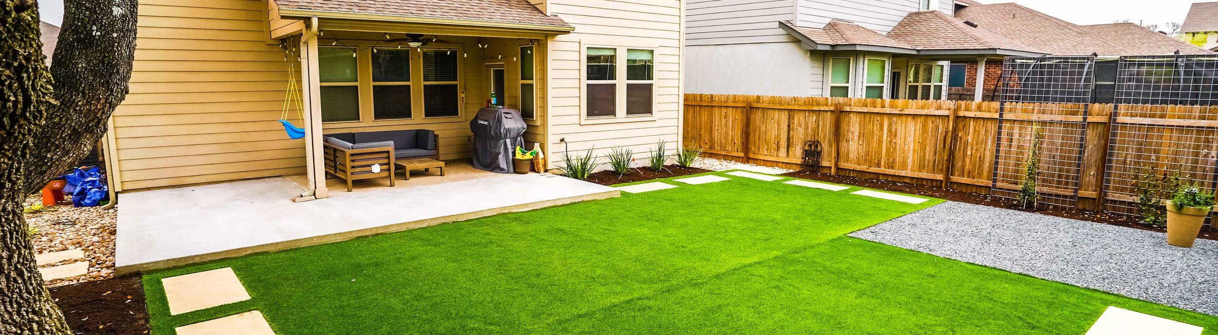 Round Rock backyard with turf panels, stepping stones, gravel, and planting beds watered on separate irrigation zones