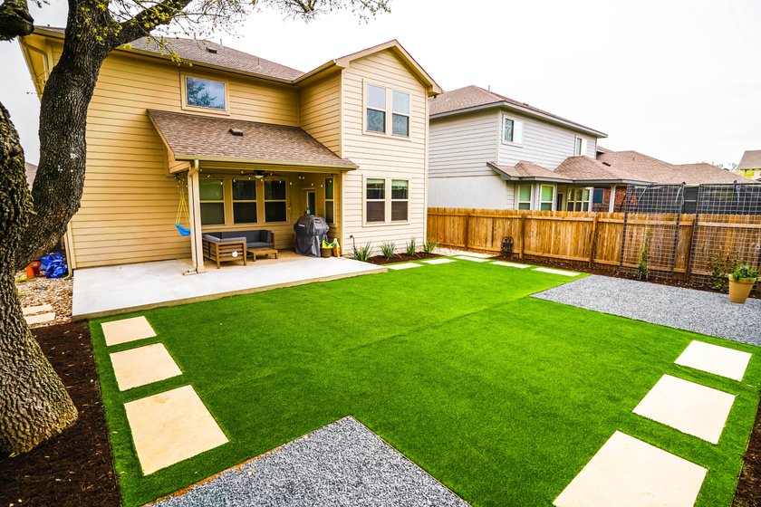 Round Rock backyard with turf panels, stepping stones, gravel, and planting beds watered on separate irrigation zones