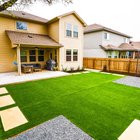 Round Rock backyard with turf panels, stepping stones, gravel, and planting beds watered on separate irrigation zones