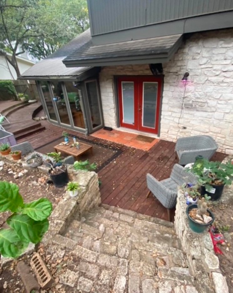 Sloped Shoal Creek backyard before grading, where bare soil runs toward the house