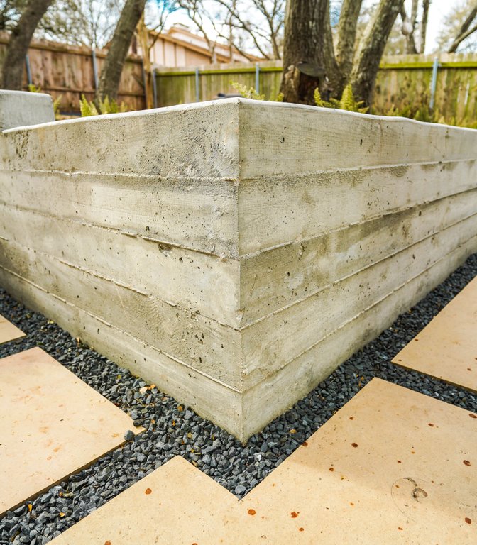 Shoal Creek backyard with concrete retaining walls, flagstone, and gravel