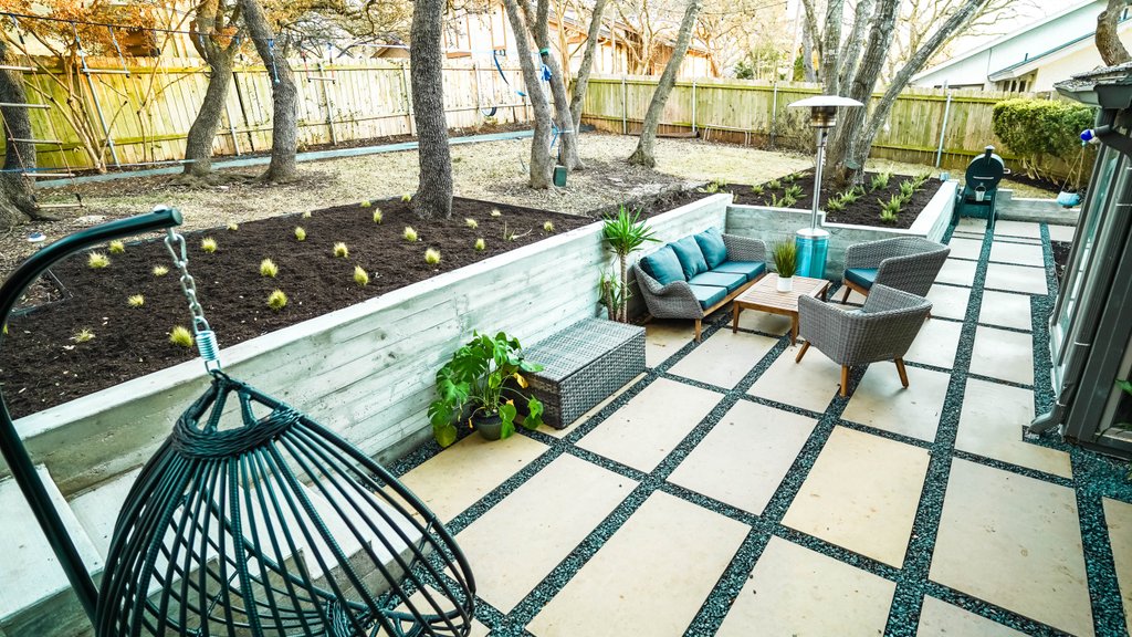 Finished terraced backyard with concrete walls, flagstone patio, and fresh planting beds in Austin