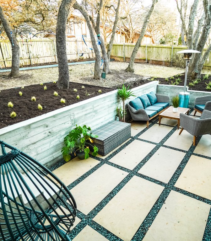 Same Austin backyard after grading and terracing, with level patios and drained planting beds
