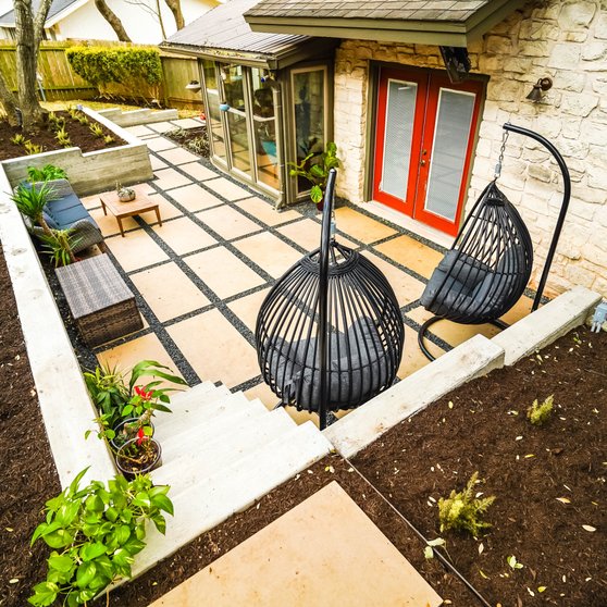 Multi-level terraced backyard with concrete retaining walls and planting beds in Austin