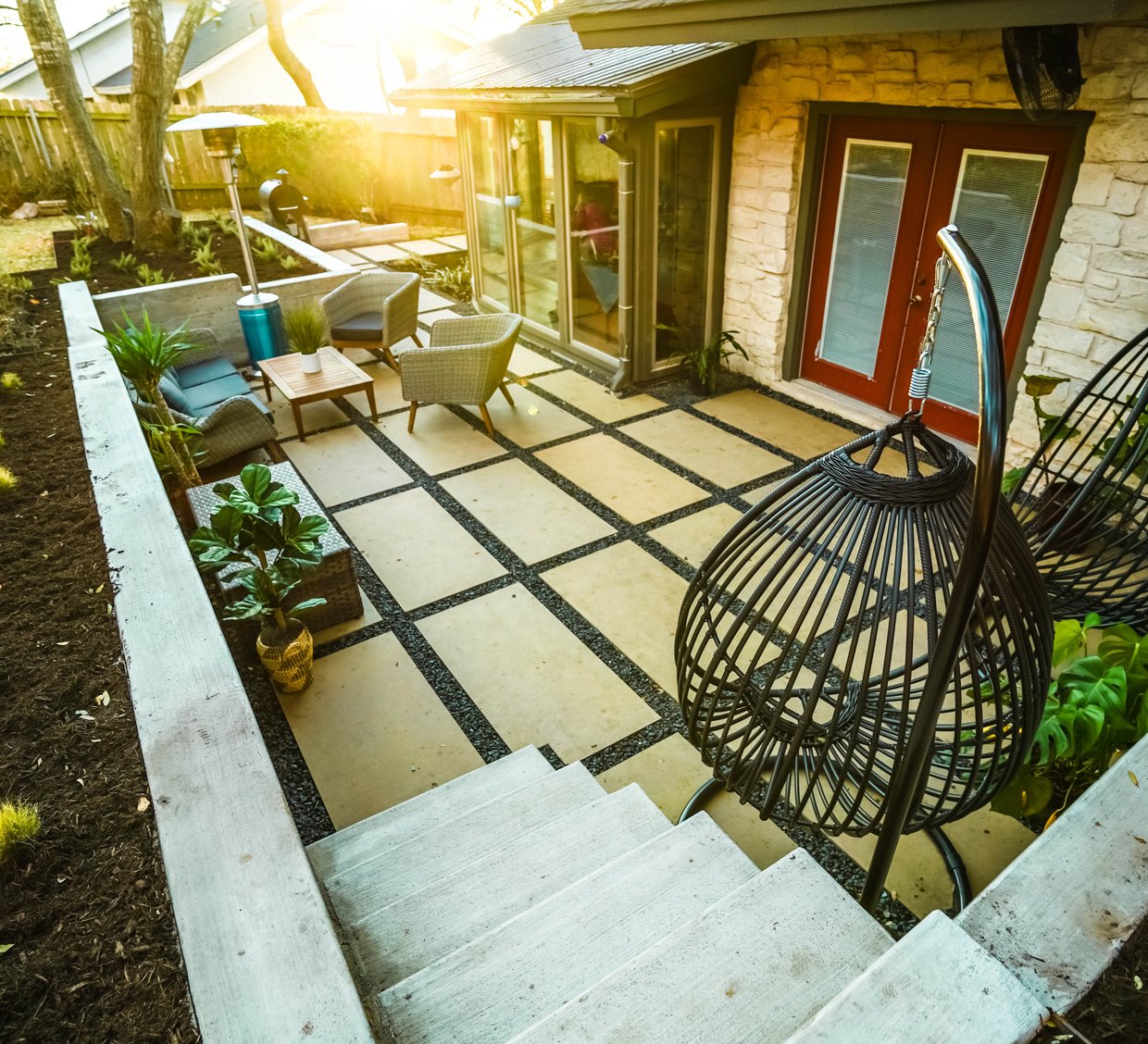 Shoal Creek terraced backyard with board-formed concrete walls and cream paver patios