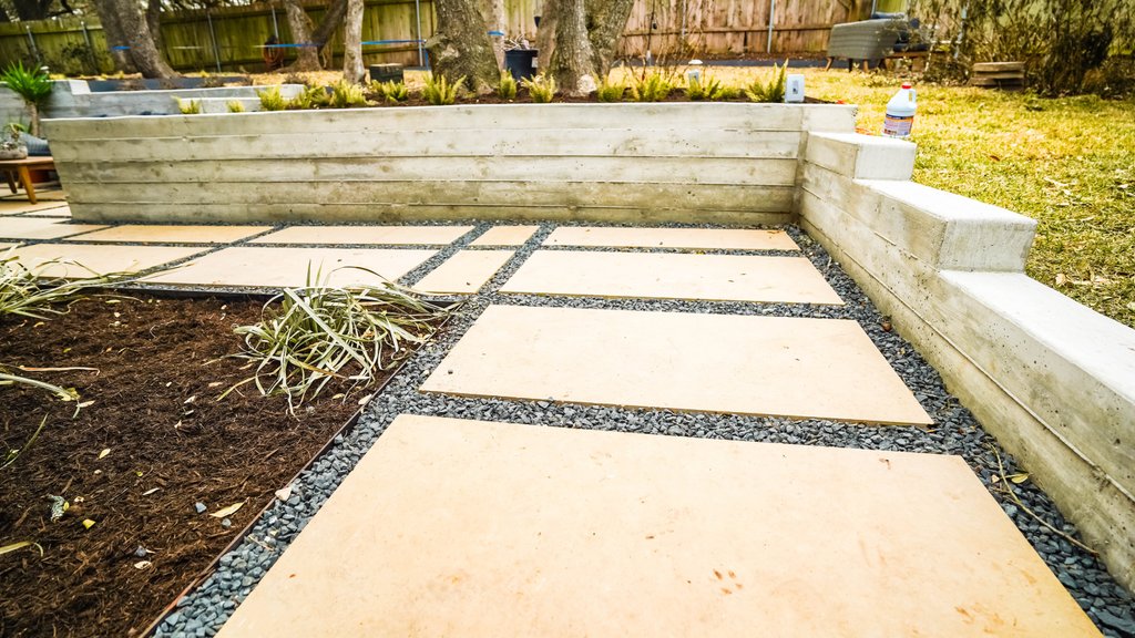 Shoal Creek backyard concept realized with terraced flagstone patios, concrete walls, and steps