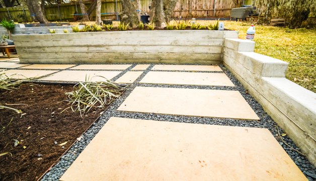 Flagstone patio set above a concrete retaining wall in an Austin backyard