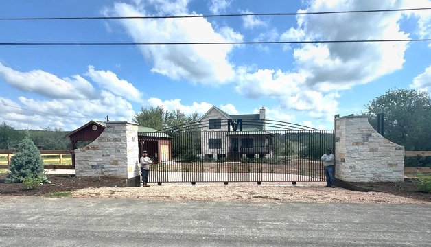 Driveway entry gate with stone columns on a ranch property near Austin