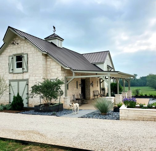 Limestone ranch home and gravel driveway entrance in the Central Texas Hill Country