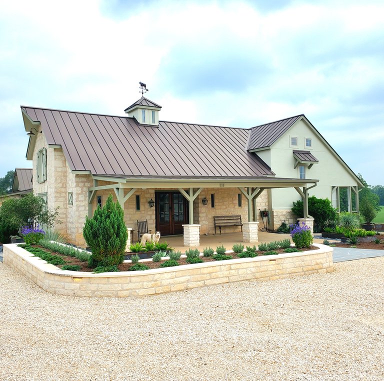 Stone retaining walls and planter beds at a Smithville-Ranch home landscape installation