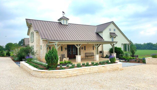 Stone retaining walls holding a graded slope into level planter beds at a Smithville-area home