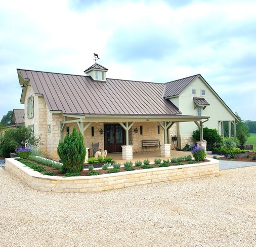 Stone retaining walls forming terraced planter beds at a Central Texas property