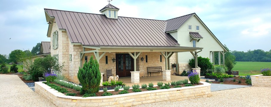 Stone retaining walls and planted beds terracing a Smithville ranch slope to hold soil and slow runoff during heavy rain