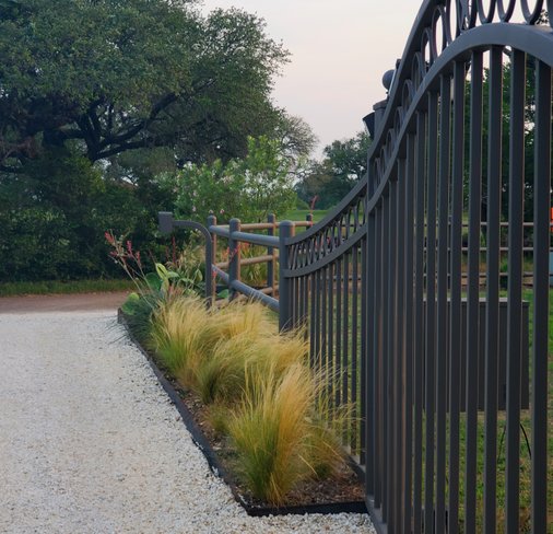 Metal perimeter fence and gate at a Smithville-area ranch near Austin