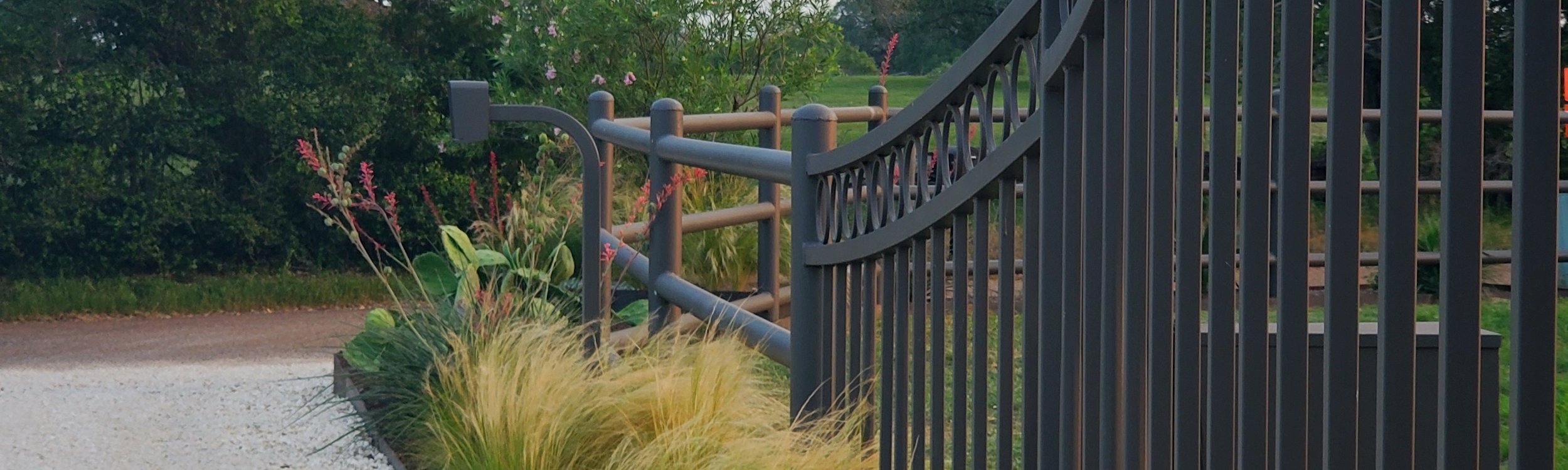 Powder-coated iron fence lining a Smithville Hill Country ranch driveway