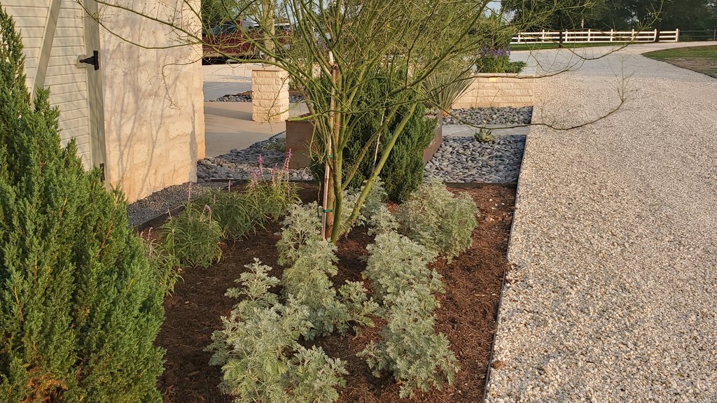 Cleared planter bed prepped and edged before mulch at a Smithville-area home