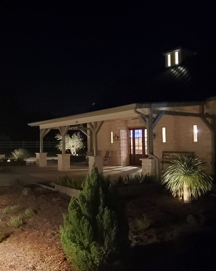 Cedar and timber pavilion with a metal roof and stone columns at a Central Texas home