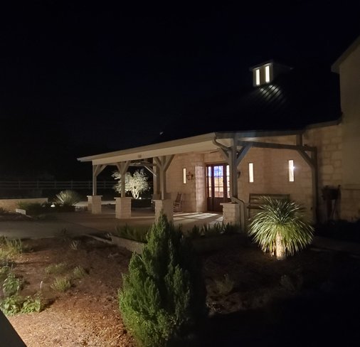 Shielded landscape lighting on a stone pavilion amid Smithville xeriscape