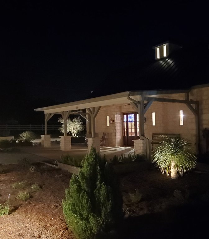 Low-voltage fixtures lighting a stone pavilion amid Smithville xeriscape