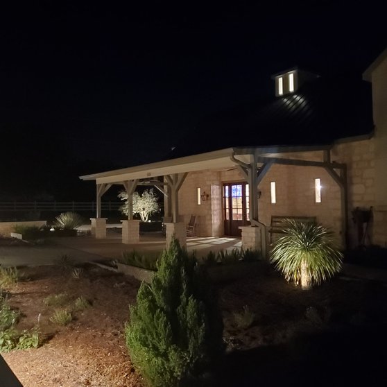 Stone pavilion with finished landscape lighting at night in Smithville