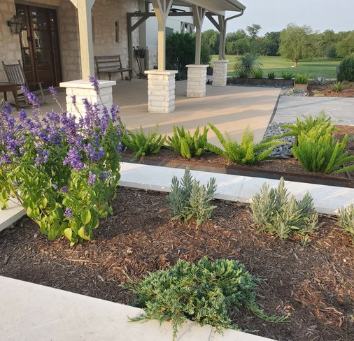Stone planter beds bordering a flagstone walkway at a Smithville ranch home