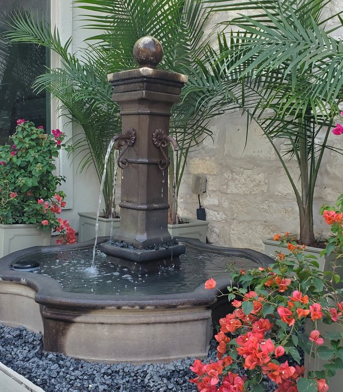 Refreshed beds with flowers around a water fountain at Smithville-Ranch