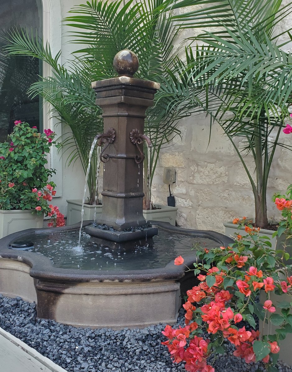Water fountain surrounded by flowering plantings