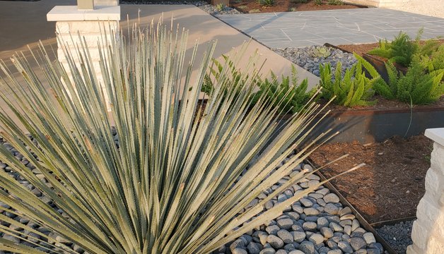 River rock channel and planted slope used for erosion control at a Central Texas home