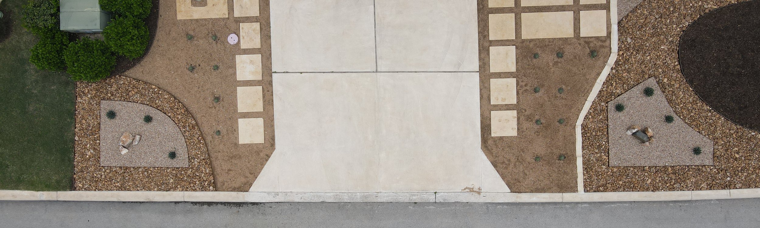 Aerial view of an interlocking paver driveway with gravel borders at a Spicewood, Austin home