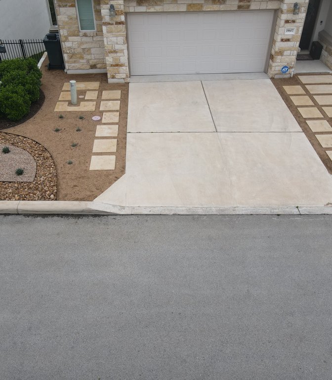 Paver driveway with gravel borders and ornamental grasses at a Spicewood, Austin home