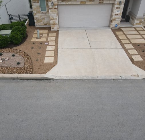 Spicewood driveway with pavers, gravel, and grasses over a graded, draining surface