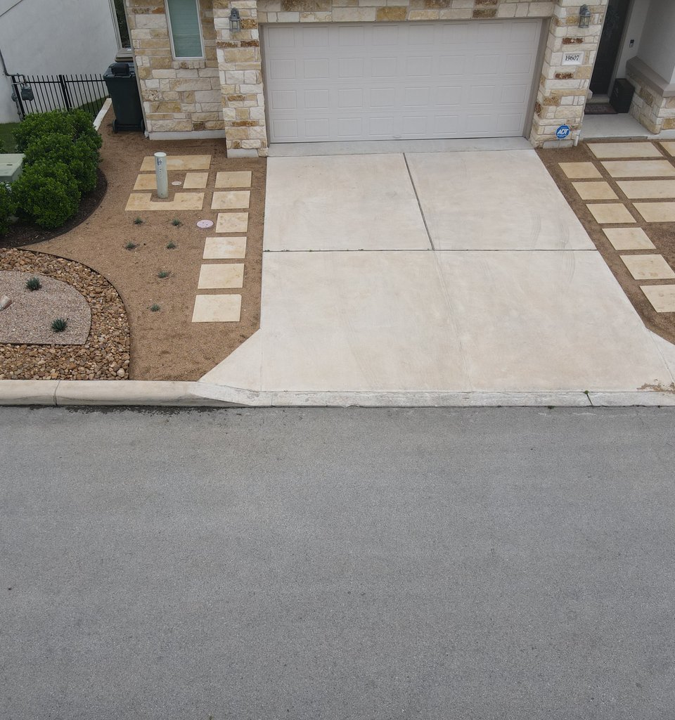 Spicewood front-of-home driveway with limestone pavers, gravel xeriscape, and ornamental grasses