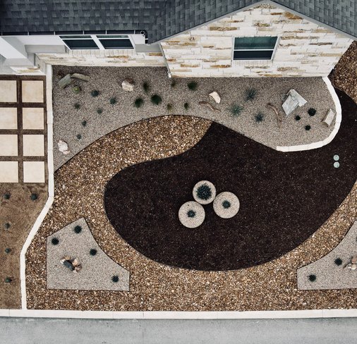 Aerial of a water-wise Spicewood front-yard renovation with gravel, mulch, and pavers