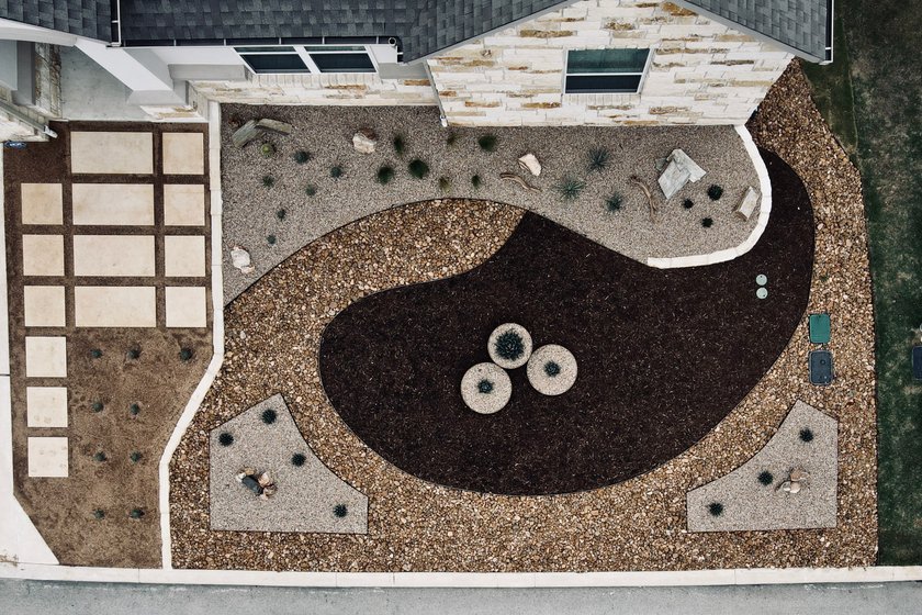 Aerial view of an Austin xeriscape with gravel, mulch beds, ornamental grasses, and paver walkways