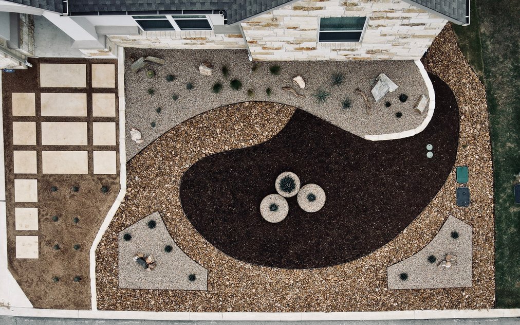 Aerial view of an Austin xeriscape with gravel, mulch beds, ornamental grasses, and paver walkways
