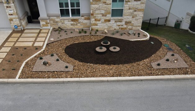 Drought-tolerant Spicewood front yard with gravel, mulch, and native planters