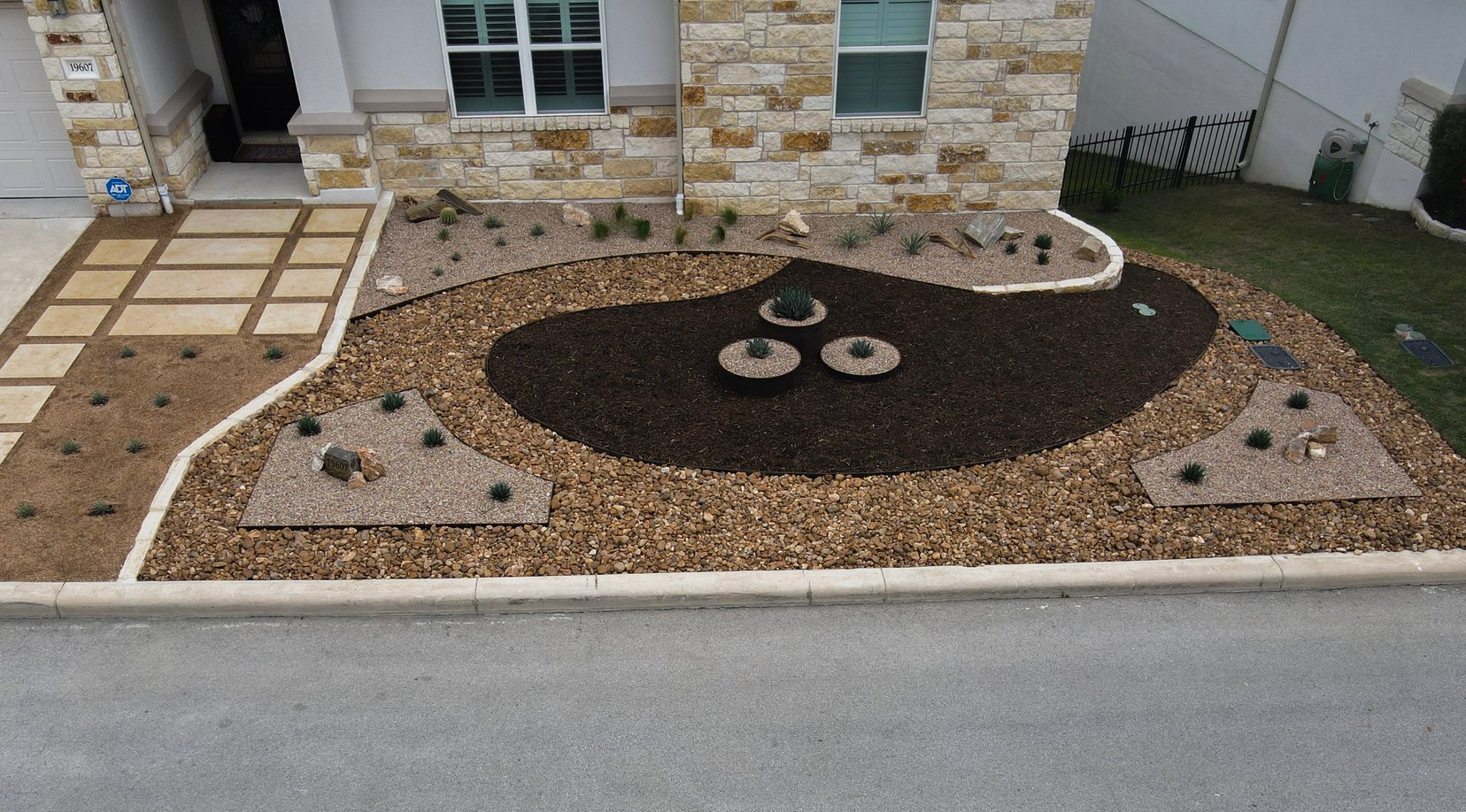 River rock, decomposed granite, and drought-tolerant plantings with native boulders