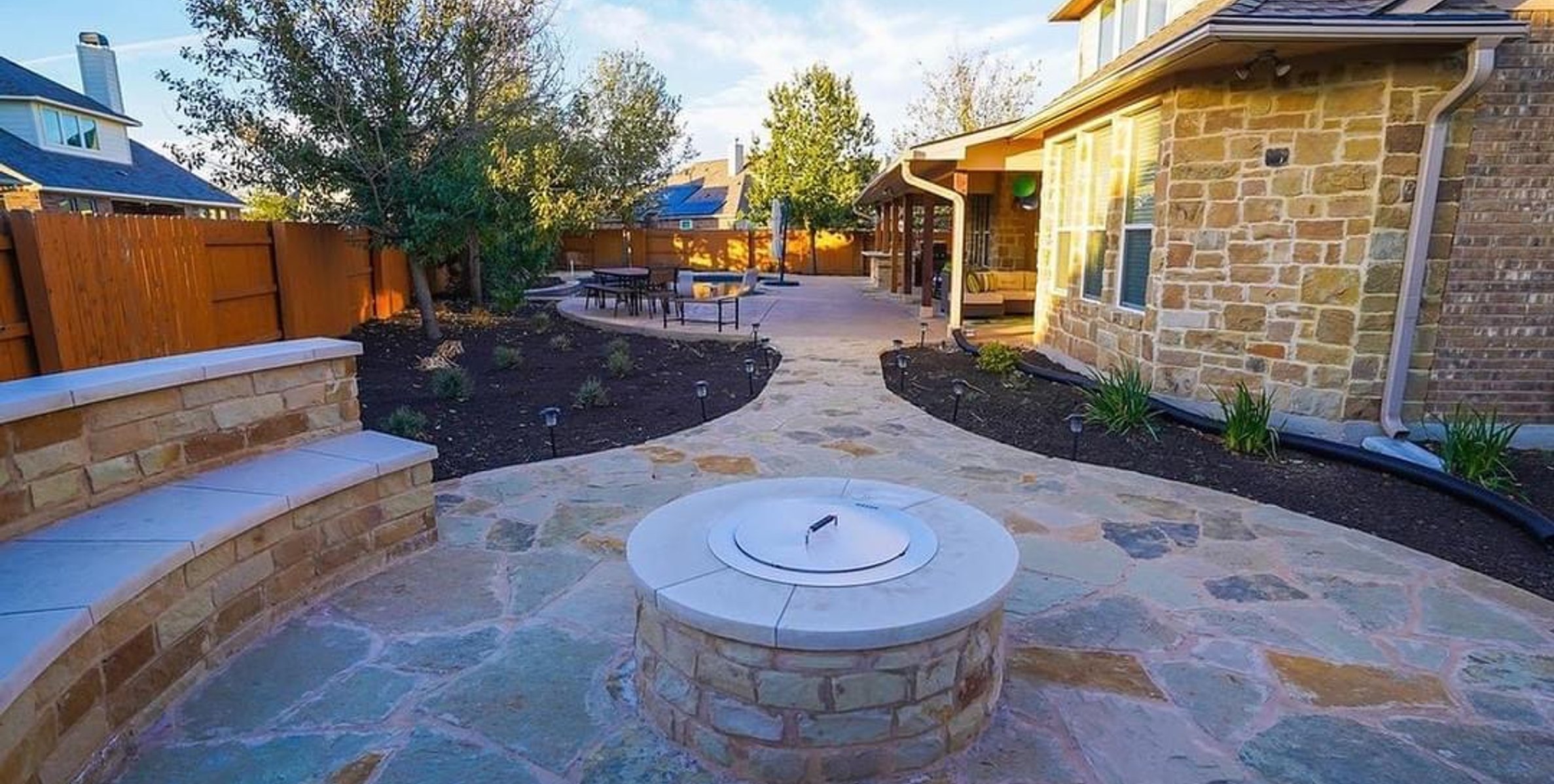 Fire pit and seating wall set between the kitchen and the pool