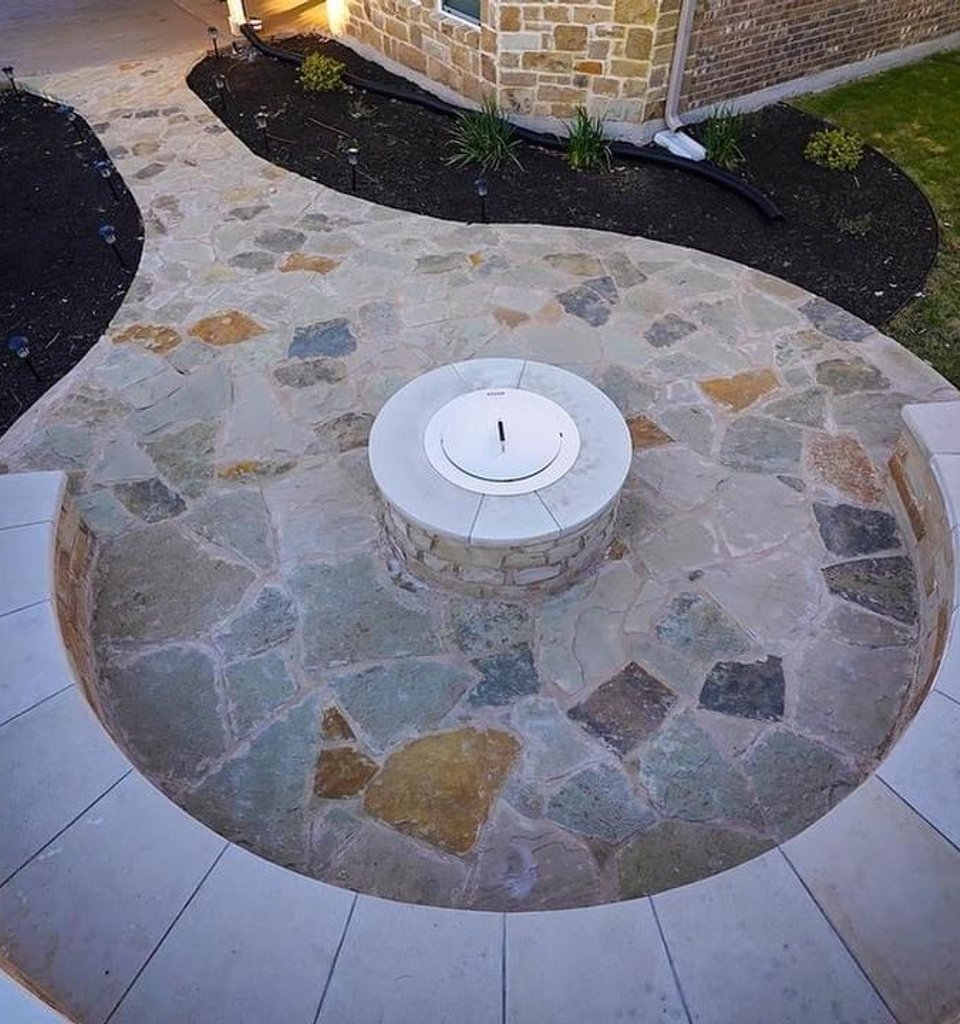 Steiner Ranch flagstone fire pit with a bench seating wall and planting beds