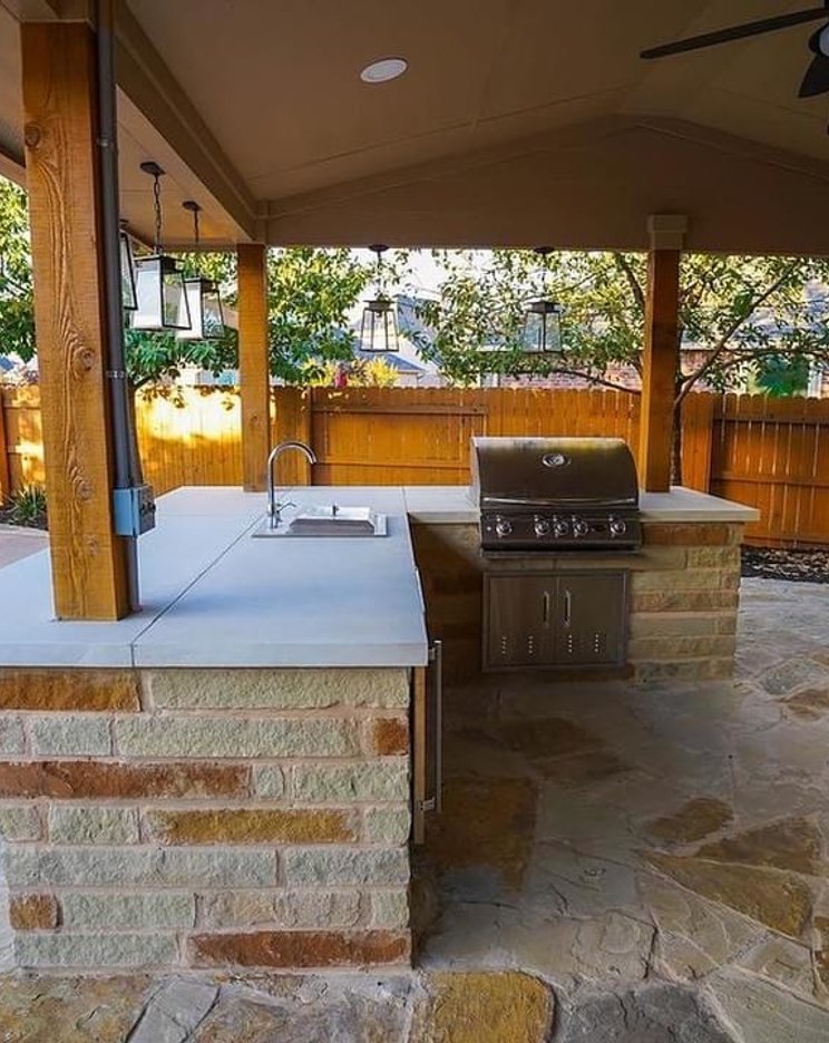 Pergola shading an outdoor kitchen and grill beside the pool at a Steiner Ranch home