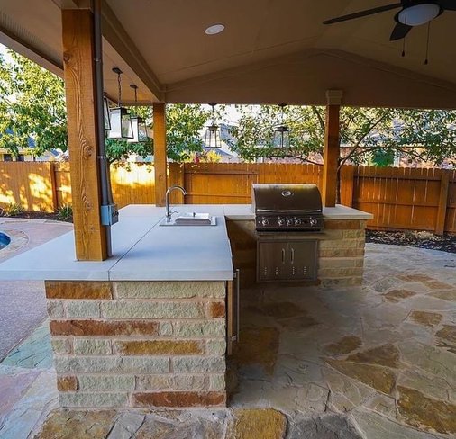 Outdoor kitchen with grill and pergola beside the pool at Steiner Ranch