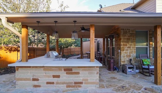 Outdoor living space with a pergola, outdoor kitchen, and flagstone patio at a Steiner Ranch home