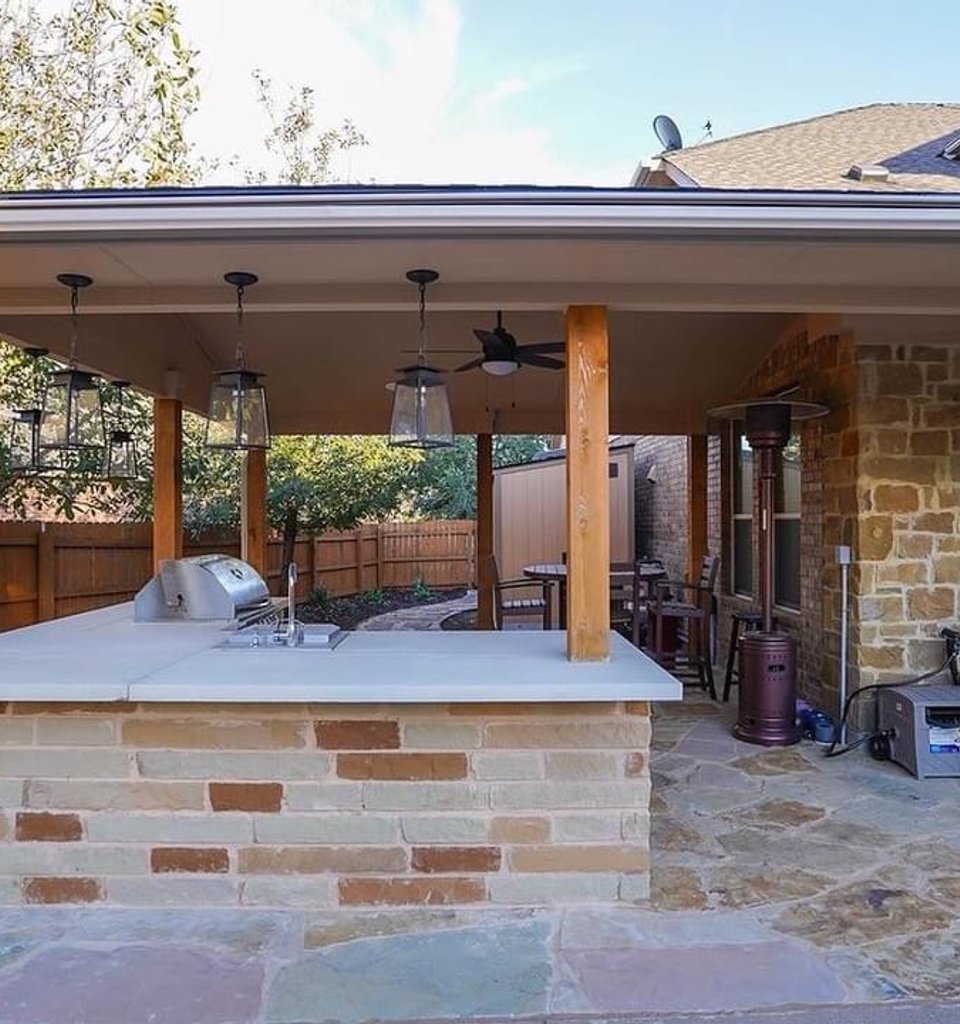 Steiner Ranch covered outdoor kitchen and flagstone patio beside a pool