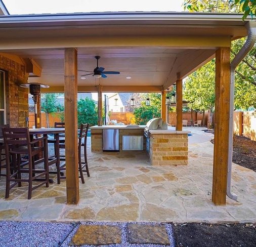 Flagstone patio with a pergola and outdoor kitchen in a Steiner Ranch backyard