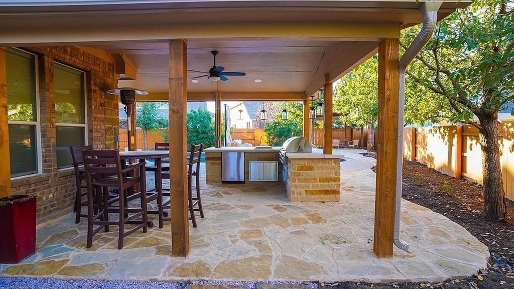 Pergola design over an outdoor kitchen and flagstone patio at a Steiner Ranch home
