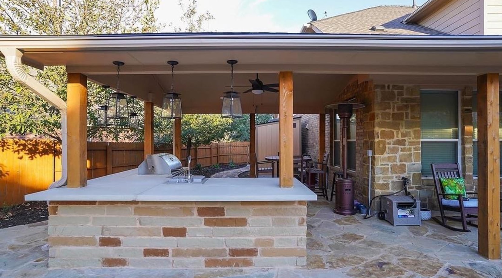 Timber pavilion sheltering the stacked stone outdoor kitchen
