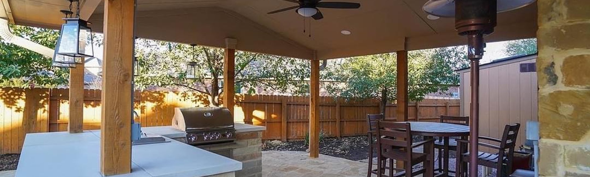Custom outdoor kitchen with a built-in grill under a pergola on a flagstone patio in Steiner Ranch, Austin