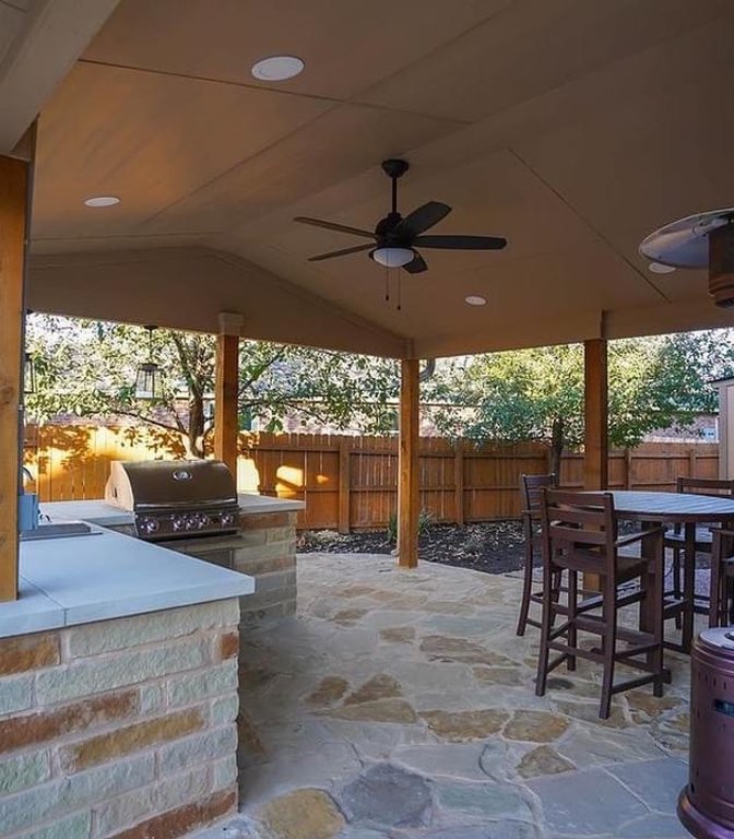 Built-in gas grill in a stone island under a pergola in Steiner Ranch, Austin