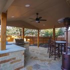 Built-in outdoor kitchen with a stainless grill under a cedar pergola next to a flagstone patio in Steiner Ranch near Austin