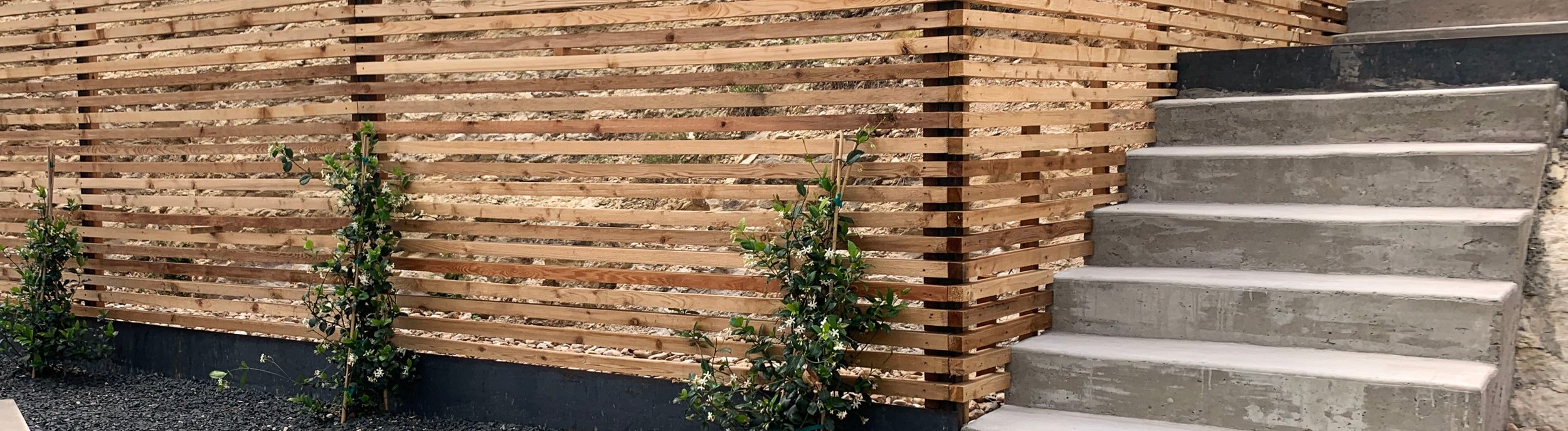 Multi-level Westlake Hills, TX terrace with horizontal cedar slat fence, concrete steps, and limestone pavers by Thrive Landscape and Design